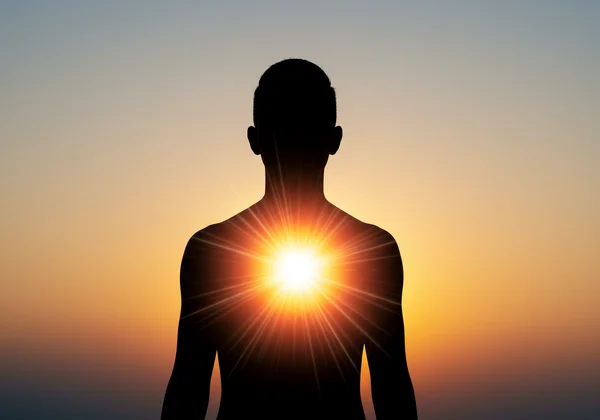 Person's silhouette connecting with glowing inner self.
